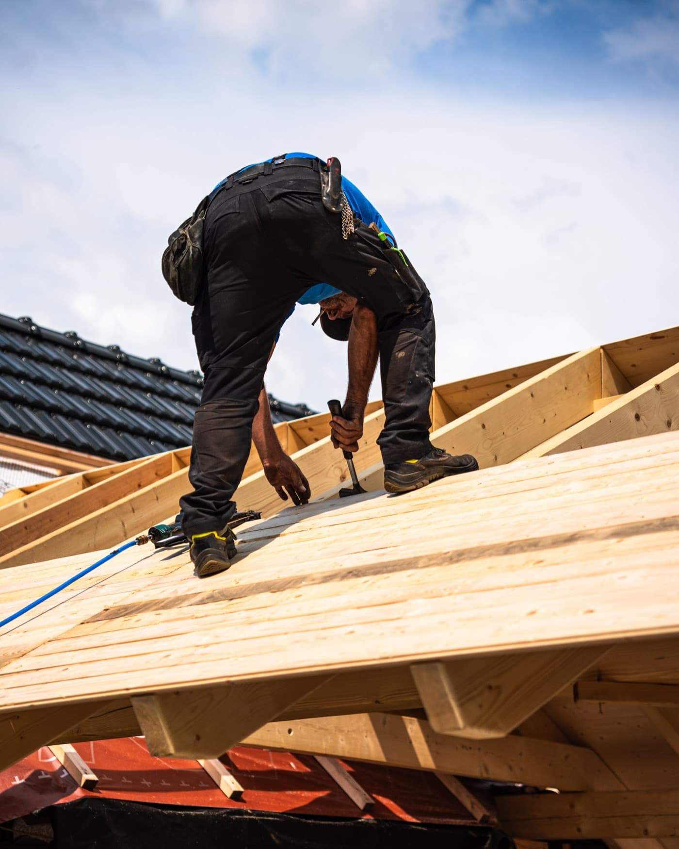 Dachdecker arbeitet auf dem Dachstuhl eines Neubaus